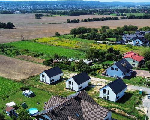 Nowe domy w sąsiedztwie terenów zielonych / Ujazd