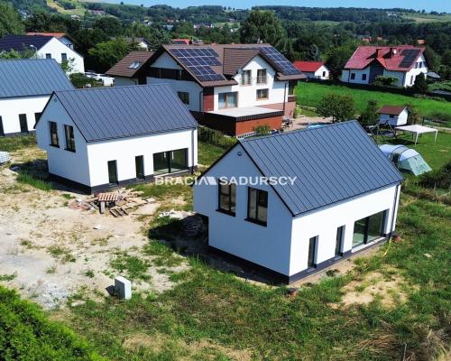 Nowe domy w sąsiedztwie terenów zielonych / Ujazd